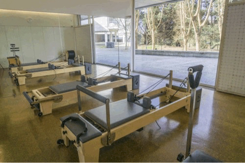 Reformers em fila junto à porta envidraçada do estúdio