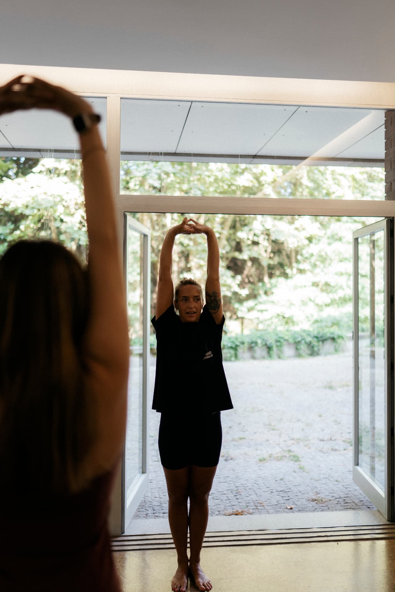 Instrutora a conduzir a aula de Matwork junto às portas de vidro